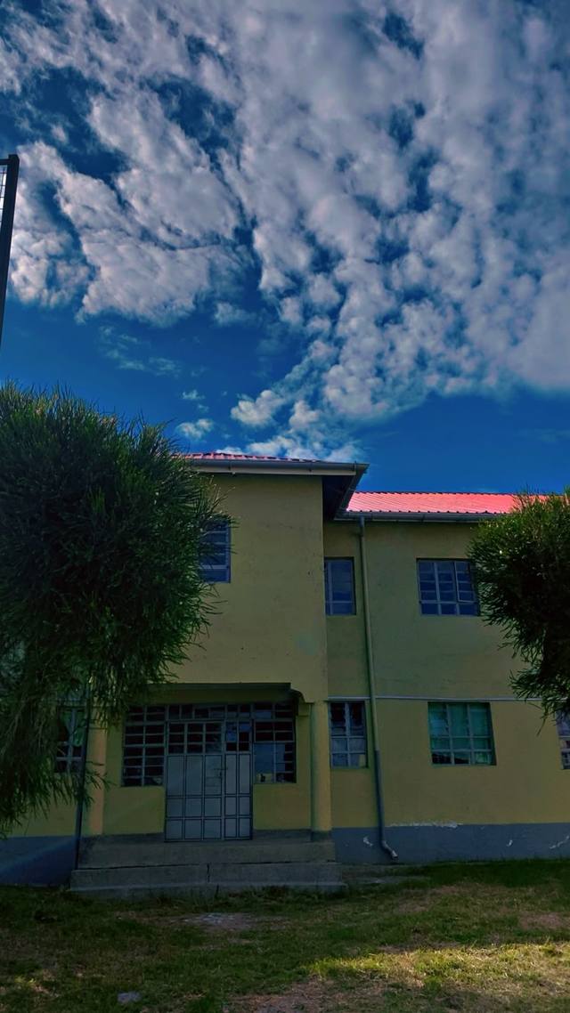 A two-storey classroom block with a red roof