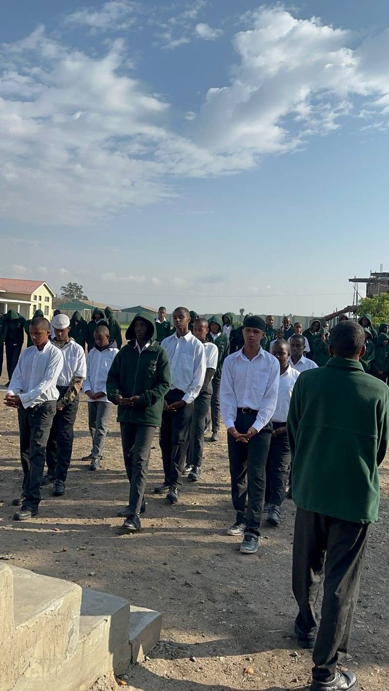 ASA students in green uniforms standing in rows at a school gathering