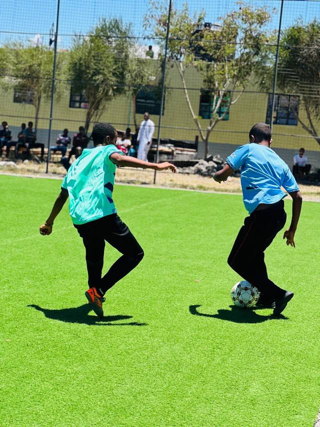 Students playing football on the school pitch